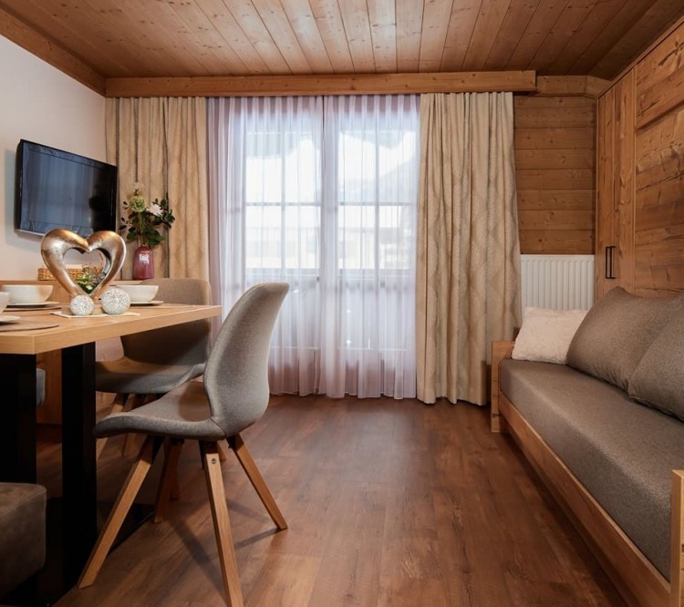 Modern renoviert - Sitzecke mit Stuhl und Couch im Appartement in Flachau